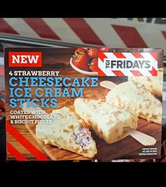 a box of cheesecake ice cream sticks with strawberries on the side in a store window