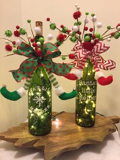 two wine bottles decorated with christmas decorations and lights