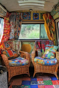 two wicker chairs sitting next to each other in front of a window with curtains