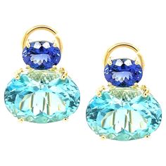 These impressive earrings feature a beautifully matched pair of Swiss blue topazes that have a combined weight of over 23 carats! The large sparkling ovals are set horizontally with gorgeous African tanzanites in an original color block design that is both contemporary and timeless. Handcrafted in 18k yellow gold by our Master Jewelers in Los Angeles, these bright pops of color will give a look of updated elegance to both casual and dressy attire! Perfect for both daytime and evening wear! Earrings measure 3/4" in length, 5/8" across Swiss blue topazes, 16 x 12mm, 23.66 carats total Tanzanites, 8 x 6mm, 2.68 carats total Dressy Attire, Vaseline Glass, Color Block Design, Blue Topaz Earrings, Topaz Earrings, Swiss Blue Topaz, Block Design, Tanzania, Deep Blue