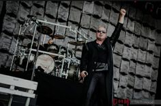 a man standing on top of a stage with his arms in the air