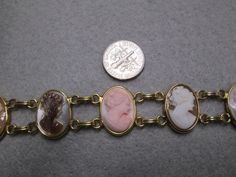 "Such an exquisite cameo bracelet! This one is rather rare, 6 beautiful genuine hand carved cameos are the focal point of this stunning piece. It is vintage 50's/60's Van Dell, new old stock, in excellent vintage condition. Well made in 12kt. gold filled to last for many years to come! It is 7 1/4\" long and 3/4\" wide. A double locking alligator clasp for security. Six different genuine shell cameos interlocking with polished gold, just gorgeous. Of course it is hallmarked Van Dell, and 12kgf." Gold Retro Bracelets With Vintage Charm, Collectible Victorian Gold Jubilee Bracelet, Antique Brass Bracelet With Vintage Charm, Antique Brass Bracelets With Vintage Charm, Antique Gold Vintage Bracelet With Charm, Vintage Brass Jubilee Bracelet, Antique Charm Bracelet For Formal Occasions, Antique Gold Cabochon Bracelets, Antique Jubilee Bracelet Collectible