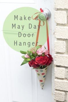 a sign that says make may day door hanger with flowers in it on a door