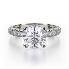 a white gold engagement ring with diamonds on the band and an oval cut center stone