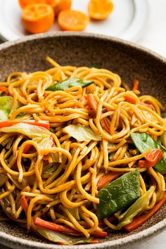 a bowl filled with noodles and vegetables on top of a table