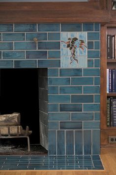 a blue brick fireplace with a bench in front of it and bookshelves behind it