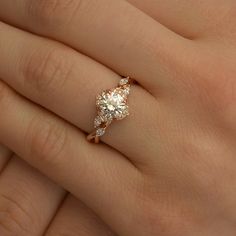 a woman's hand with a diamond ring on top of her finger and an engagement band