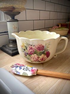 a flowered bowl and spatula sitting on a counter