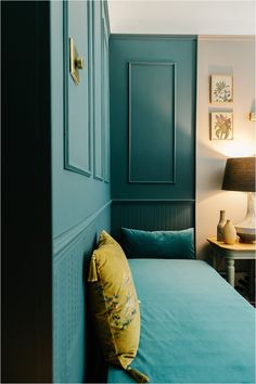 a bedroom with blue walls and green bedding