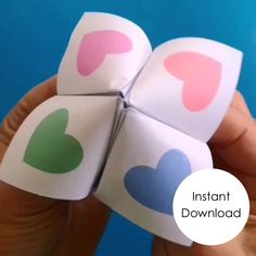 someone is holding four paper hearts with the words instant love on them in front of a blue background