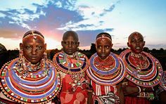 four african women in colorful clothing standing next to each other with their hands on their hips