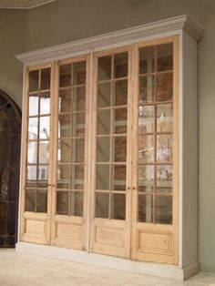 an empty room with glass doors on the wall and wood flooring in front of it