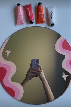 a person taking a selfie in front of a mirror with three different colors on it