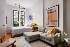 a living room filled with furniture and a large poster on the wall next to a bed