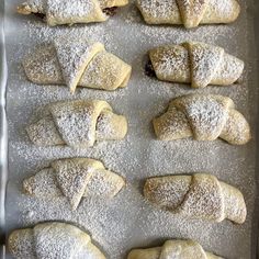 several pastries on a baking sheet covered in powdered sugar are ready to go into the oven