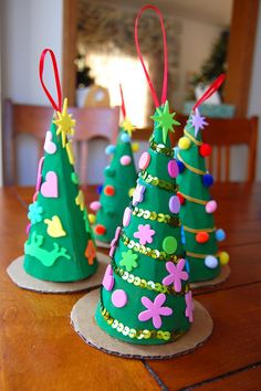 three small christmas trees sitting on top of a wooden table