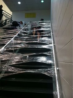 some people are walking up the stairs covered in plastic