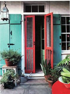 an orange and blue house with potted plants