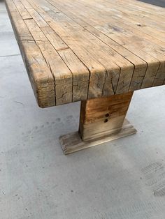 a wooden bench sitting on top of a cement floor