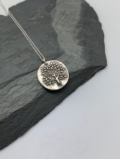 This unique tree of life handmade embossed round pendant has been entirely handmade using .999 fine silver. It has been cut from fine silver precious metal clay, textured, fired and oxidized. The pendant hangs from a sterling silver diamond cut cable chain. This fine silver pendant features an embossed tree of life on one side of the pendant and is reversible to a tiny leaves embossed pattern on the reverse side. Pendant size: approximately 3/4 x 3/4 inches Chain length: adjustable at 16 and 18 Moon Necklace Silver, Layered Necklaces Silver, Pendant Necklace Silver, Precious Metal Clay, Unique Trees, Charm Necklace Silver, Silver Tree, Oxidised Jewellery, Tree Pendant