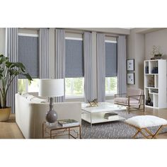 a living room filled with furniture and windows covered in blue blinds on top of them