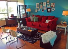 a living room with red couches and blue walls