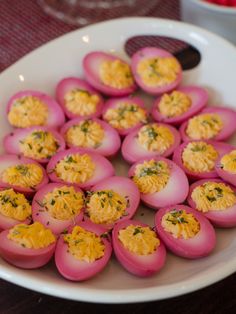 a white plate topped with deviled eggs covered in cheese