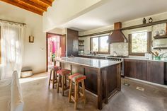 an open kitchen and living room area with bar stools