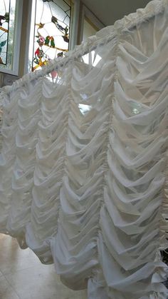 the curtain is made out of white fabric