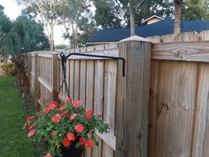 a potted plant on the side of a wooden fence with flowers growing in it