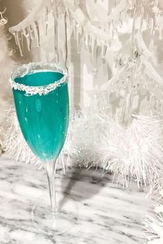 a blue glass sitting on top of a marble table next to a white christmas tree