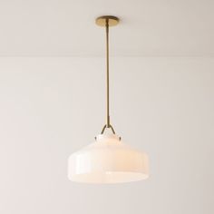 a white light hanging from a ceiling fixture in a living room or dining room area