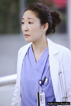 a woman in scrubs is walking with a stethoscope around her neck