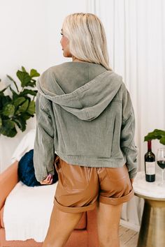 - Layer your look with trendy casual style in this must-have jacket! - Lightweight olive colored denim material - High round neckline with hooded back with drawstring closure - Long, loose sleeves with button closure cuffs - Functional chest pockets - Relaxed silhouette that falls to a straight hemline with back accent pleats. Measurements S : Bust 44", Hip 40", Length 17.5", Sleeve Length 18", Waist 42". M : Bust 46", Hip 42", Length 18", Sleeve Length 18", Waist 44". L : Bust 48", Hip 44", Length 19", Sleeve Length 18.5", Waist 46". Trendy Washed Hoodie For Fall, Spring Cotton Utility Hooded Jacket, Spring Cotton Hooded Jacket For Everyday, Everyday Spring Cotton Hooded Jacket, Casual Hooded Jacket For Spring, Casual Spring Hooded Jacket For Everyday, Spring Streetwear Utility Jacket With Drawstring Hood, Casual Olive Cotton Utility Jacket, Casual Spring Utility Jacket With Drawstring Hood