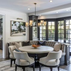 a table with chairs around it in front of large windows and doors to the outside