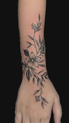 a woman's hand with a flower tattoo on it