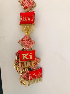 two red and gold brooches hanging from a white wall