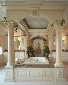 a large bathroom with columns and a jacuzzi tub in the middle of it