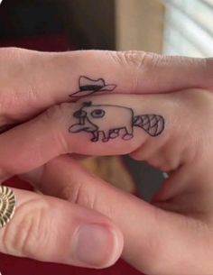 two people with tattoos on their fingers holding each other's hands and one has a small cow tattoo on it