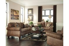 a man sitting in a living room next to two couches