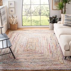 a living room with a large window and rugs on the floor in front of it