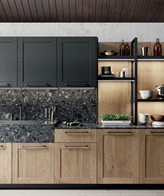 a kitchen with wooden cabinets and marble counter tops, along with black appliances on the wall