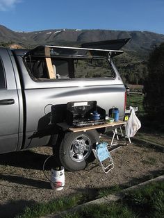 a silver truck parked on top of a dirt field