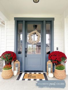 the front door is decorated with red flowers and wreaths