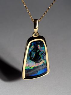 Double-sided necklace with natural Australian Boulder Opal in 18K yellow gold gemstone origin - Queensland, Australia gem size is about 15 x 25 mm weight of the Opal - 17.75 carat pendant length - 38 mm pendant weight - 6.15 grams The necklace comes with a 18K gold plated silver chain. Blue Opal Gemstone Necklaces, Luxury Opal Gemstone Necklaces, Luxury Artisan Opal Necklace, Blue Opal Multi-stone Jewelry, Boulder Opal Pendant, Australian Boulder Opal, Boulder Opal, Queensland, Gold Plated Silver