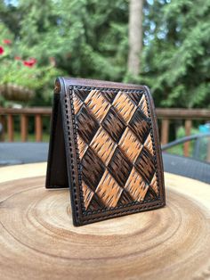 a wallet sitting on top of a wooden table next to a tree stump in front of some trees