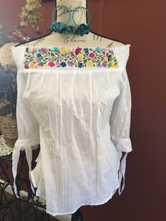 Gorgeous hand embroidered Mexican blouse is comfortable, fresh and stylish With beautiful San Antonio flower embroidery detailed work on the top The fabric is cotton, fresh, gauzy and slightly see through, 3/4 sleeve Get the Boho style you like Perfect to wear with your favorite jeans Perfect for summer season! You will love your unique one of a kind piece Is a MUST HAVE in you wardrobe Every blouse is individually handcrafted Color may vary on stitching as each blouse is unique Perfect for any Bohemian Cotton Blouse With Tonal Embroidery, Summer Blouse With Floral Embroidery And 3/4 Sleeve, Traditional Tonal Embroidered Top For Spring, White Cotton Embroidered Top With Tonal Embroidery, White Cotton Blouse With Tonal Embroidery, Cotton Blouse With Floral Embroidery And 3/4 Sleeves, Summer Bohemian Blouse With Tonal Embroidery, Spring Cotton Blouse With Intricate Embroidery, Folk Style Blouse With Tonal Embroidery For Spring