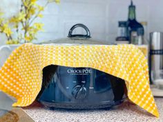 a close up of an oven on a kitchen counter with a yellow cloth over it