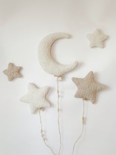 three stars and a crescent hanging on the wall next to each other with beads attached