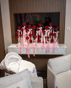 there are many red roses on the table in front of the mirror and two white chairs